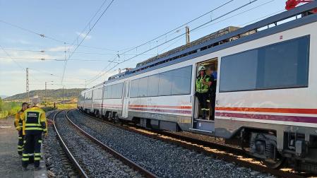 Los bomberos, junto al tren averiado