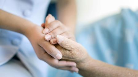 Una enfermera da la pano a un paciente hospitalizado