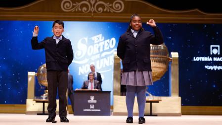 Los niños de la Residencia San Ildefonso de Madrid Ainhoa Rosero (d) y Axiel Kyron (i) muestran el número 11.840, un tercer premio