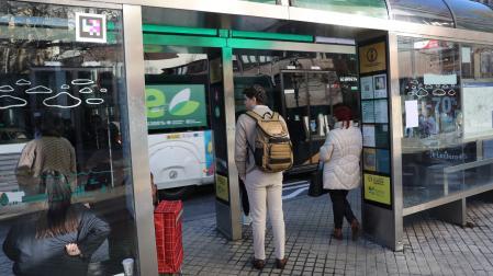 Usuarios aguardan en una marquesina para incorporarse a una de las villavesas en Pamplona