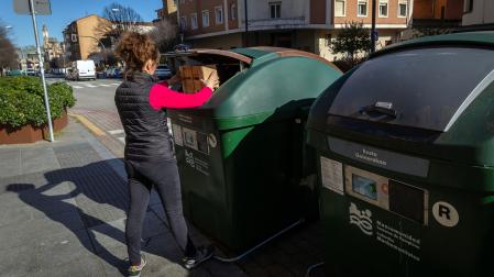 Una mujer deposita residuos en un contenedor de la calle Olite de Pamplona