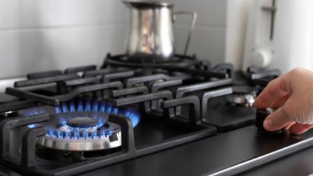Una persona enciende el gas de una cocina