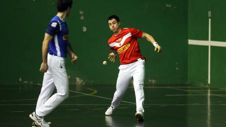 Josu Eskiroz golpea a una pelota en presencia de Martija en el partido de ayer por la noche en el Ereta de Tafalla /