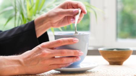 Una mujer, con una taza de infusión