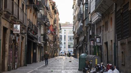La calle Estafeta, a las 8 de la mañana del domingo, con restos de la fiesta de la noche anterior: botellas, cartones de comida, cristales y copas