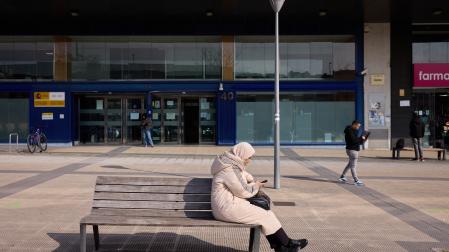 Una mujer consulta su móvil en las inmediaciones de la oficina de Extranjería de Pamplona