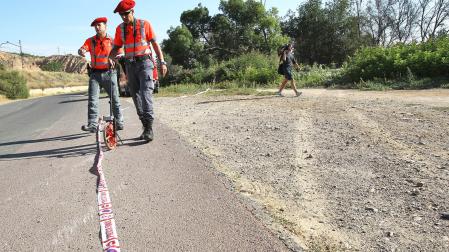 Agentes de la Policía Foral junto a las marcas que dejó el coche al salirse del asfalto, antes de caer a la acequia, en el accidente mortal de La Mejana ocurrido en agosto de 2012 /