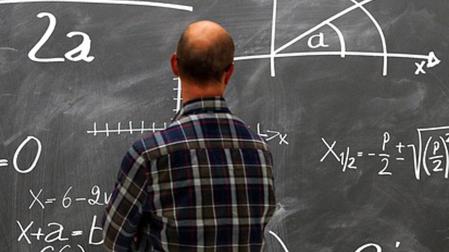 Un profesor observa una pizarra