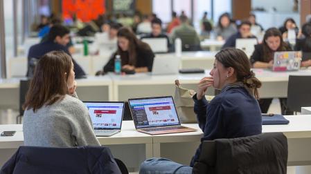 Un par de estudiantes frente al ordenador, en el edificio Amigos de la Universidad de Navarra
