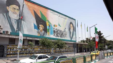 Vehículos pasan junto a un mural del Líder Supremo de Irán, el ayatolá Alí Jamenei (arriba a la izq.) y del difunto Líder Supremo, el ayatolá Ruhollah Jomeini (a la der.), en Teherán