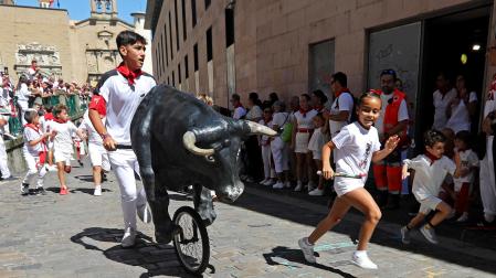 Niños y niñas disfrutan del encierro txiki con toros de ruedas