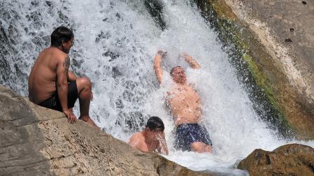 Varias personas se refrescan en la presa de Huarte durante la ola de calor del mes de agosto