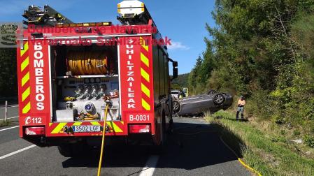 Un camión de bomberos, junto al coche accidentado este sábado en la autovía de Leizarán