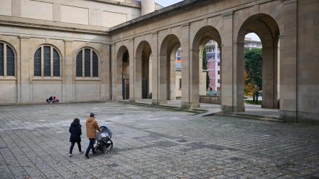 Una pareja con carrito se dispone a atravesar las arquerías del monumento, cuya descatalogación permite ahora su demolición