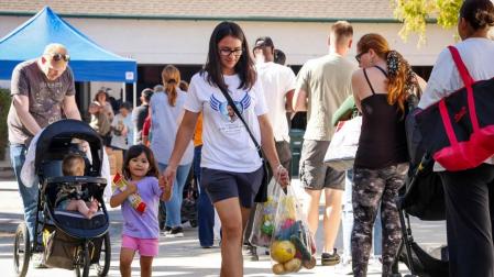 Grupos de familias hacen cola para recibir donativos de alimentos en San Diego, California