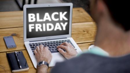 Un hombre utilizando el ordenador para buscar ofertas de Black Friday