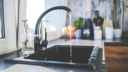 Un fregadero con el grifo abierto en una cocina