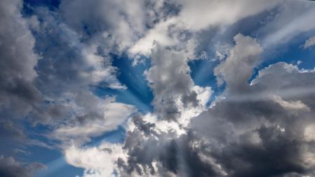 Unas nubes blancas con tenues rayos de sol