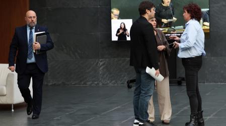 El consejero de Hacienda, José Luis Arasti, pasa junto a Pablo Azcona (Geroa Bai), Laura Aznal (EH Bildu) y Ainhoa Unzu (PSN), en el Atrio del Parlamento el pasado jueves, cuando la Cámara celebraba sesión plenaria