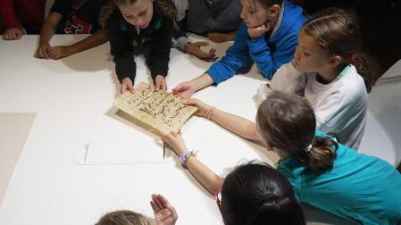 Varios alumnos examina una partitura durante una de las visitas al Archivo Municipal de Pamplona /