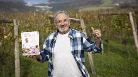 Karlos Arguiñano posa con un ejemplar del libro 'Cocina para todos' /