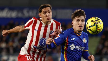 El centrocampista del Getafe Adrián Liso (d) pelea un balón con el defensa argentino del Atlético de Madrid Manuel Molina