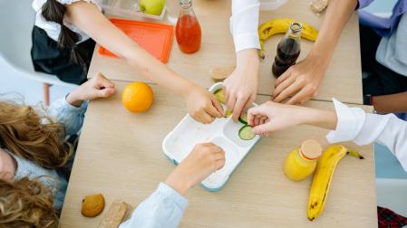 Un grupo de menores acerca sus manos en una mesa del comedor escolar de San Donato, en Etxarri Aranatz.