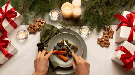 Una mesa de Navidad con un plato de zanahorias y coles de Bruselas