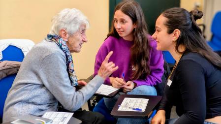 Una participante en el taller intergeneracional conversa con dos estudiantes de Psicología en la UPNA.