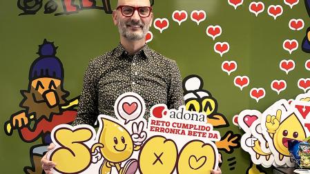 David Busto sujeta el cartel tras la donación 5.3000 que cerraba el objetivo de Adona.