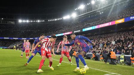 El delantero británico del FC Barcelona, Marcus Rashford (d), protege el balón ante el defensa argentino del Atlético de Madrid, Nahuel Molina