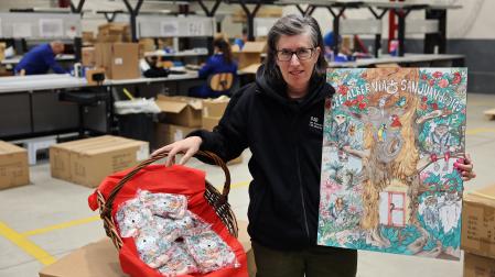 *La pamplonesa Sonia Muñoz Artieda, de 51 años, posa con su dibujo que ilustra los polvorones Anaut esta Navidad.
