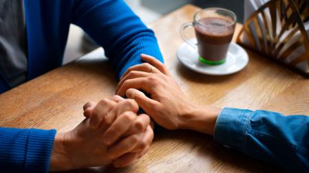 Una persona muestra su apoyo y empatía a otra tocándole el brazo
