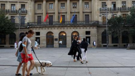 Paseantes frente a la sede del Gobierno de Navarra, en Pamplona