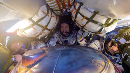 Los astronautas Jonny Kim (izda.) Sergey Ryzhikov (centro) y Alexey Zubritsky dentro de la Soyuz MS-27