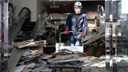 Un hombre limpia los desperfectos causados por el terremoto