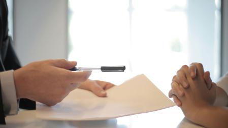 Dos personas cerrando un contrato.