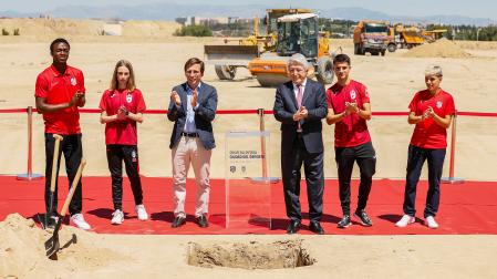 El alcalde de Madrid, José Luis Martínez Almeida, y el presidente del Atlético de Madrid, Enrique Cerezo, en la puesta de la primera piedra de la Ciudad del Deporte junto a promesas de la cantera del equipo rojiblanco y dos atletas del club de Suances en julio de 2024