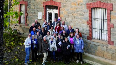 Presentación del libro en el instituto La Granja, con presencia de familiares y antiguos empleados de las granjas experimentales de Pamplona. Ante el cartel que recuerda el pasado del centro.