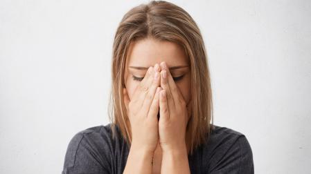 Una mujer se tapa la cara para llorar