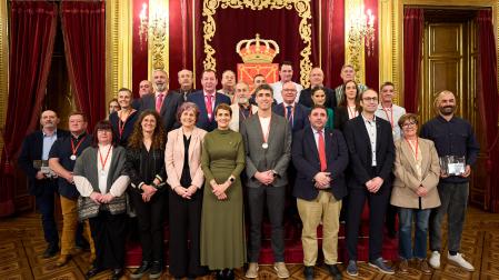 EN EL SALÓN DEL TRONO. De izda. a dcha., atrás: Andrea Lusarreta (Federación Navarra de Pelota), Amaia Osaba (piragüismo), Miguel Moreno (arbitraje béisbol), Roberto Martínez (lucha), Miguel Ángel Ruiz (tiro olímpico), José Luis Severiano Arcelus (pelota), José Miguel Gabriel (tiro con arco), José Ángel Lerga (Oberena), Txemari Garaikoetxea (CDBaztan), Ignacio Perurena (herri kirolak), Epifanio Pejenaute (patinaje), Estefanía Unzu (atletismo), Álvaro Sexmilo (tenis),  Luis López Gastón (pelota), Marta Unzué (fútbol), Miguel Ángel Urós (pelota); delante, Marino Oscoz (Beti Onak), Jordi Celaya(deporte adaptado), María Paz Extremado (Club Natación), Garbiñe Bueno (concejala), Rebeca Esnaola (consejera), María Chivite (presidenta del Gobierno),  Unai Hualde (presidente del Parlamento), Jorge Agirre (director del Instituto Navarro de Deporte), Lucía G. Treviño (Ayuntamiento de Viana) y Felipe Palacios (Peña Sport).