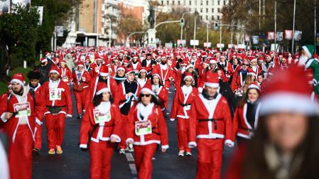 Participantes de todas las edades recorren el centro de Madrid vestidos de papá noeles durante la 14ª edición de la Carrera de Papá Noel