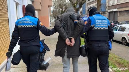 Dos agentes junto a uno de los dos detenidos