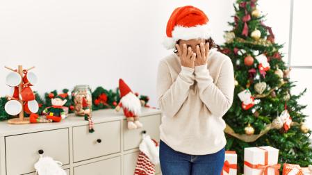 Una mujer, junto a un árbol de Navidad