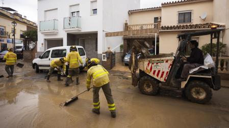 Labores de limpieza de las calles este domingo en Estación de Cártama después de los problemas sufridos anoche en la localidad por la crecida del río Guadalhorce