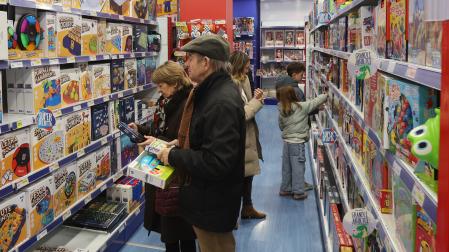 Tres generaciones distintas eligen sus regalos para los Reyes Magos en una juguetería de Pamplona