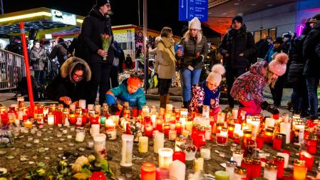 Varias personas colocan velas en memoria de los fallecidos en Suiza