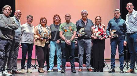 Trabajadores jubilados posan en el escenario tras recibir el homenaje.