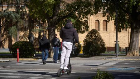 Un hombre se dispone a cruzar un paso de cebra sobre su patinete, una maniobra no autorizada, ya que hay que bajarse del vehículo