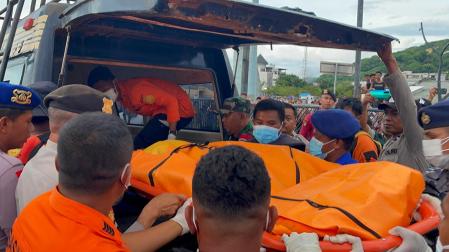 Los equipos de rescaten introducen en un vehículo los restos del cuerpo sin vida del niño recuperado de las aguas